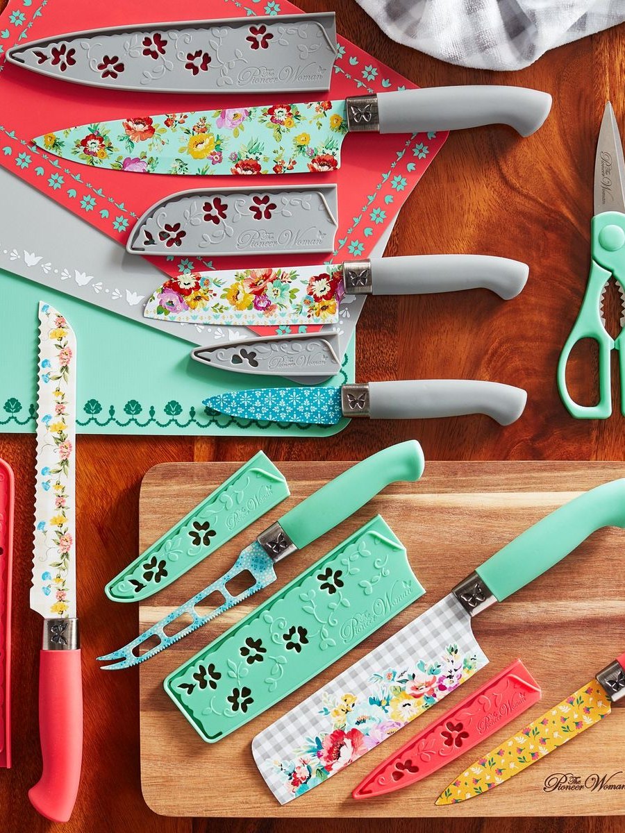 Pioneer Woman cutlery set with floral and teal sheaths on a wooden board