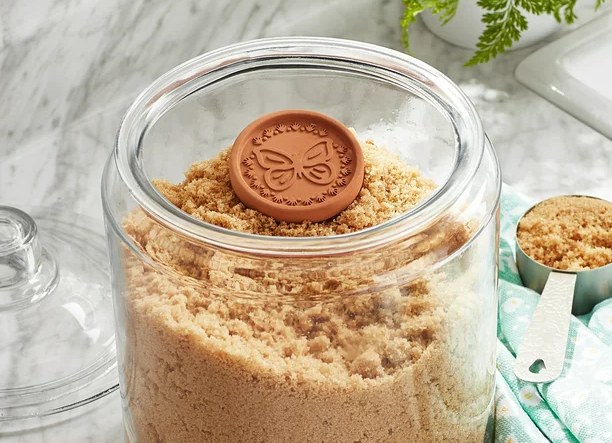 Pioneer Woman butterfly sugar saver in a glass canister of brown sugar